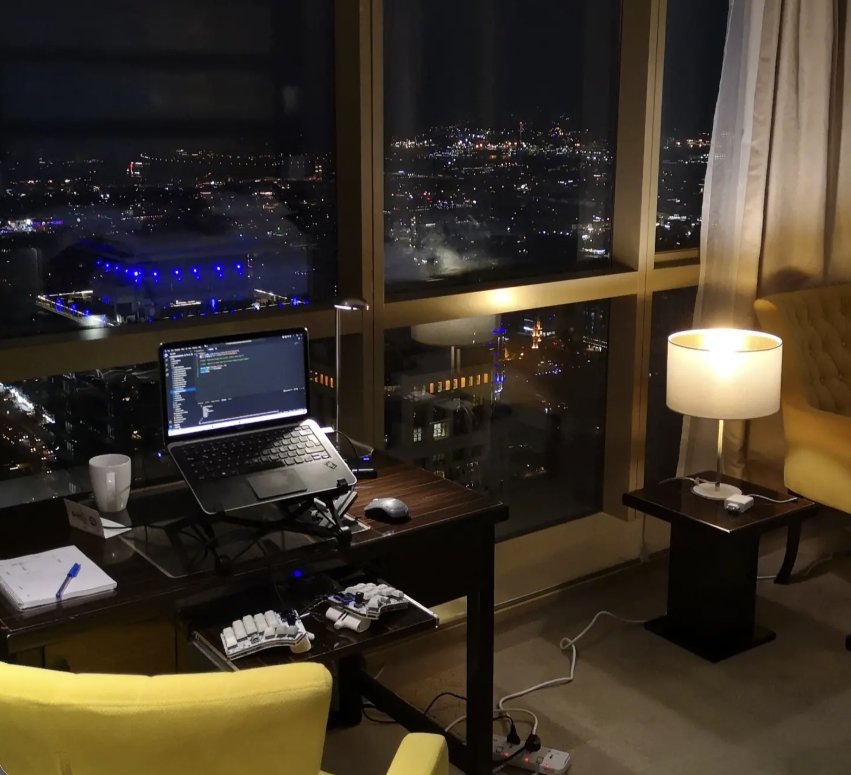Laptop and software-development workspace by a nighttime city view