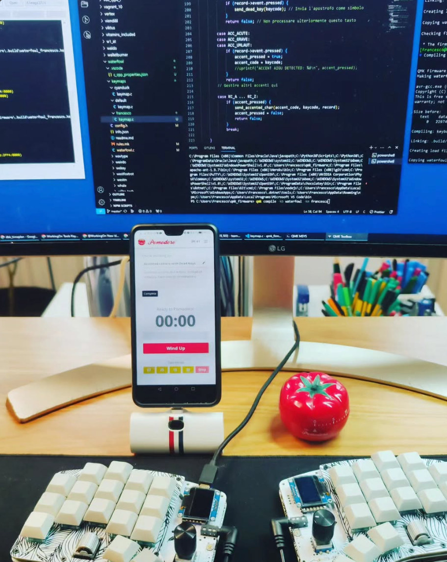 Software development workbench with code, custom keyboards, and a Pomodoro timer
